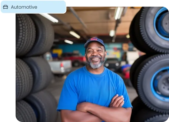 A smiling auto shop owner, representing payment solutions for the automotive industry.